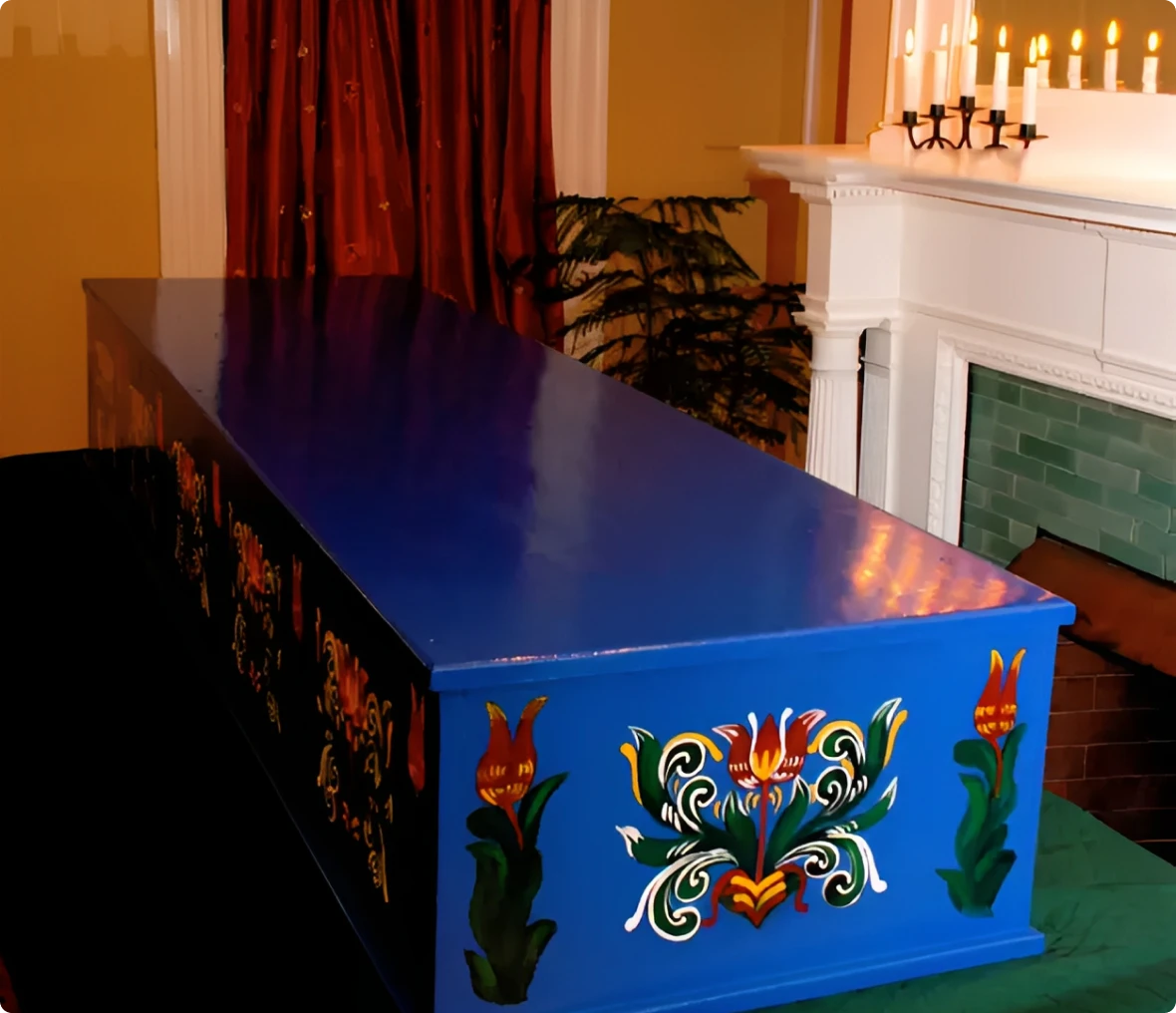 Ornate blue coffin beside a fireplace