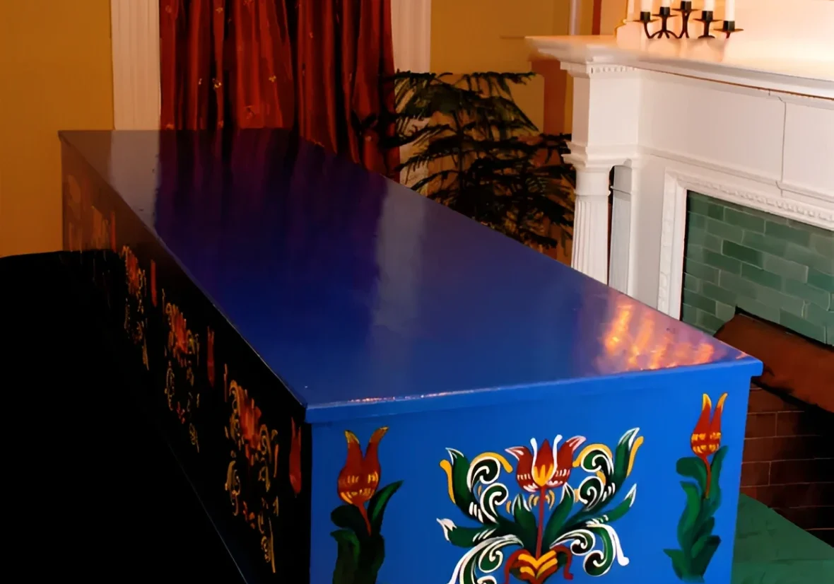 Ornate blue coffin beside a fireplace